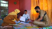 Dua guru SMA Negeri 1 Kabila mengawasi siswa yang melakukan ujian semester secara luar jaringan (luring) di rumah di Poowo, Kabupaten Bone Bolango, Gorontalo, Selasa (9/6/2020).