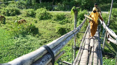 Potret Guru Lewati Jembatan Bambu untuk Antar Soal Ujian