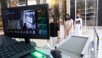 Pengunjung yang akan masuk ke dalam mal dan harus melewati pemeriksaan suhu badan otomatis menggunakan kamera dan hasilnya bisa dilihat di layar. Kemudian pemeriksaan x-ray untuk barang bawaan.