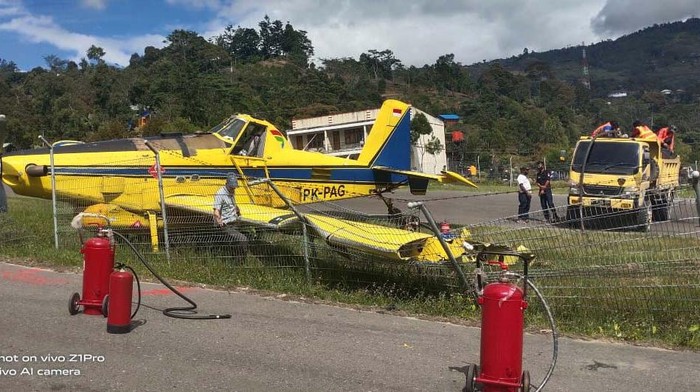 Momen Pesawat Pengangkut BBM Tergelincir di Papua Pesawat pengangkut bahan bakar minyak (BBM) tergelincir di landasan Bandara Karubaga di Tolikara, Papua. Begini kondisinya.