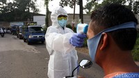 Untuk melindungi diri dari virus Corona, petugas memerika pengendara dengan memakai APD di Jalan Transit Bantargebang, Kota Bekasi, Selasa (9/6/2020).
