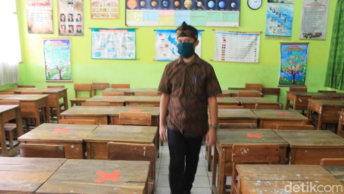 Petugas sekolah di Kabupaten Bandung memeriksa protokol kesehatan di dalam ruang kelas.