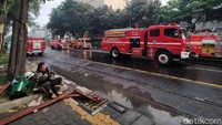 Petugas pemadam kebakaran tampak kelelahan setelah bekerja memadamkan api.
