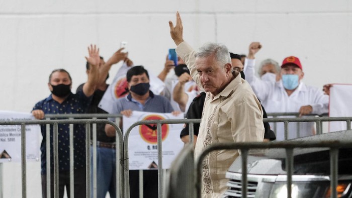 Mexican President Andres Manuel Lopez Obrador waves to supporters in Lazaro Cardenas, Quintana Roo state, Mexico, Monday, June 1, 2020. Amid a pandemic and the remnants of a tropical storm, President Lopez Obrador kicked off Mexicos return to a new normal Monday with his first road trip in two months as the nation began to gradually ease some virus-inspired restrictions. (AP Photo/Victor Ruiz)