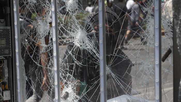 A woman hits a statue of a lion with a sledgehammer as protestors angry at the police attack the monument to Mexico's first indigenous president, Benito Juárez, during a march in which they also smashed storefronts and bus stops, in Mexico City, Monday, June 8, 2020. (AP Photo/Rebecca Blackwell)