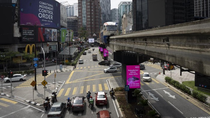 A LRT (Light Rain Transit) passes by a signboard road conditional movement control order in downtown Kuala Lumpur, Malaysia, on Sunday, June 7, 2020. Malaysian government has lifted the conditional movement order (CMCO) and replaced it with a recovery movement control order effective June 10 until Aug. 31. (AP Photo/Vincent Thian)