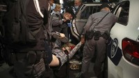 Demonstran wanita ini diangkut ke dalam mobil polisi.