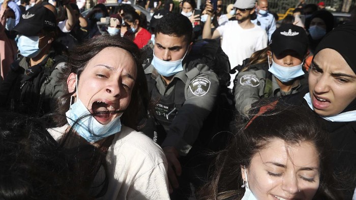 Aksi Protes Pembunuhan Pria Autis oleh Polisi Israel Israel police arrest a woman during a protest against the killing of Eyad Hallaq in Jerusalem, Tuesday, June 9, 2020. Hallaq, a Palestinian with severe autism, was killed recently by Israeli border police officers after a chase in Jerusalem's Old City after apparently being mistaken as an attacker. (AP Photo/Mahmoud Illean)
