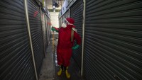 Seorang petugas sedang menyemprotkan cairan disinfektan pada kios-kios di Pasar Senen Inpres Blok VI, Jakarta, Rabu (10/6/2020).