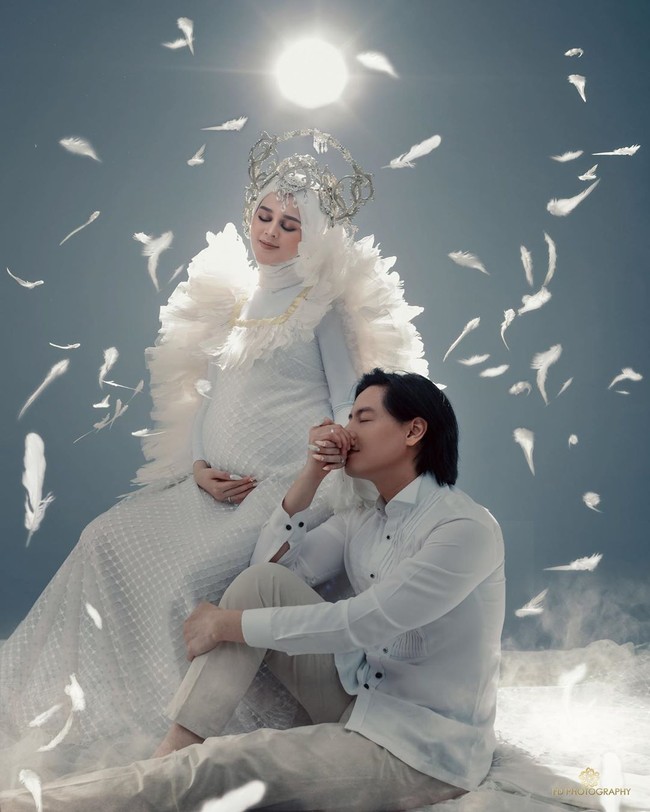 Tampil mesra, Roger tampak pose dengan mencium tangan kiri Cut Meyriska yang sedang duduk di atas kursi, sambil memegang perutnya yang semakin buncit. Foto: instagram @fdphotography90.