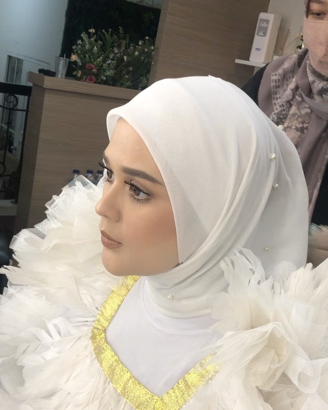 Cut Meyriska tampil memesona dengan memakai hijab segiempat bahan voal dan mengenakan inner bahan kaus warna putih berhias mutiara. Hijabnya dililit rapi ke belakang dan hanya menggunakan satu jarum pentul di bawah dagu. Foto: instagram @vuvamua.