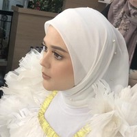 Cut Meyriska tampil memesona dengan memakai hijab segiempat bahan voal dan mengenakan inner bahan kaus warna putih berhias mutiara. Hijabnya dililit rapi ke belakang dan hanya menggunakan satu jarum pentul di bawah dagu. Foto: instagram @vuvamua.
