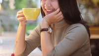 Sambil menampilkan senyuman manisnya, penjual gorengan cantik ini berpose dengan secangkir kecil kopi dan menikmati kue cokelat pesanannya. Foto: Instagram @yossykartikaas