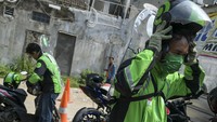 Separator atau sekat pelindung itu dipasang dengan mengikatkannya ke tubuh driver ojol. Antara Foto/Galih Pradipta.