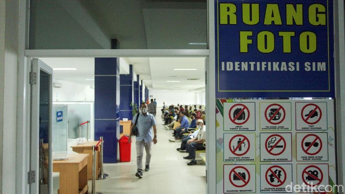 Seorang petugas tengah melayani warga yang ingin mengurus Surat Ijin Mengemudi (SIM) di Satpas Daan Mogot, Jakarta Barat, Rabu (10/6/2020). Saat pandemi Corona ini, pelayanan pembuatan SIM di Satpas menerapkan protokol kesehatan.