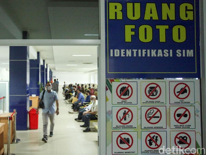 Seorang petugas tengah melayani warga yang ingin mengurus Surat Ijin Mengemudi (SIM) di Satpas Daan Mogot, Jakarta Barat, Rabu (10/6/2020). Saat pandemi Corona ini, pelayanan pembuatan SIM di Satpas menerapkan protokol kesehatan.