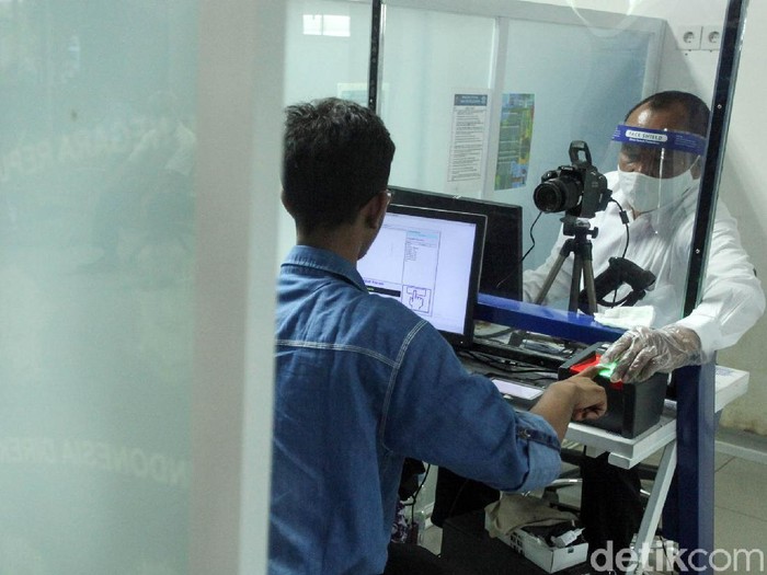 Seorang petugas tengah melayani warga yang ingin mengurus Surat Ijin Mengemudi (SIM) di Satpas Daan Mogot, Jakarta Barat, Rabu (10/6/2020). Saat pandemi Corona ini, pelayanan pembuatan SIM di Satpas menerapkan protokol kesehatan.
