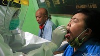 Tim medis dari Puskesmas Kecamatan Gambir memasukkan alat untuk mengambil sampel lendir di dalam hidung pedagang.