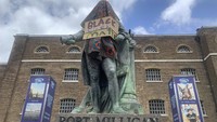 Patung Robert Milligan, yang diketahui merupakan seroang pedagang budak sekaligus pengusaha kebun gula di Inggris turut menjadi sasaran aksi vandalisme saat aksi Black Lives Matter diselenggarakan di kawasan London, Inggris. Renne Bailey/PA via AP.