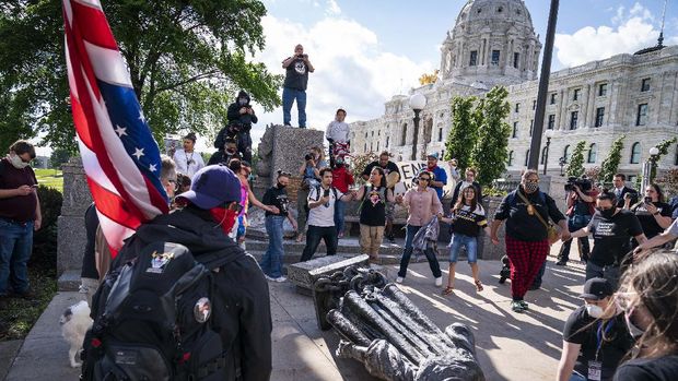 People kick at the head of a Christopher Columbus statue that was torn down at the Minnesota state Capitol in St. Paul, Minn., Wednesday, June 10, 2020. (Evan Frost/Minnesota Public Radio via AP)