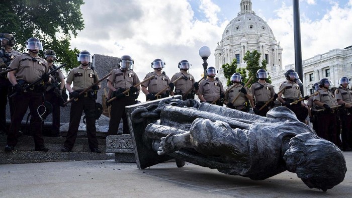 People kick at the head of a Christopher Columbus statue that was torn down at the Minnesota state Capitol in St. Paul, Minn., Wednesday, June 10, 2020. (Evan Frost/Minnesota Public Radio via AP)