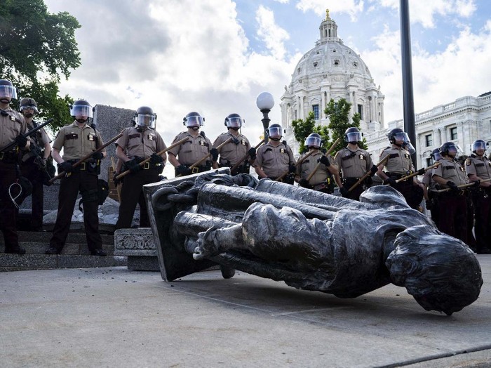 People kick at the head of a Christopher Columbus statue that was torn down at the Minnesota state Capitol in St. Paul, Minn., Wednesday, June 10, 2020. (Evan Frost/Minnesota Public Radio via AP)