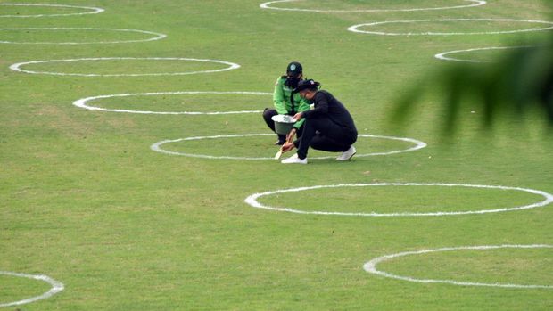 Petugas Park Ranger Kota Bogor mengecat bentuk lingkaran sebagai jarak sosial di lapangan rumput Taman Sempur, Kota Bogor, Jawa Barat, Rabu (10/6/2020). Pengecatan jarak sosial dengan bentuk lingkaran di Taman Sempur itu sebagai salah satu persiapan jelang dibukanya kembali taman tersebut dengan penerapan protokol kesehatan COVID-19 dalam masa transisi Pembatasan Sosial Berskala Besar (PSBB) di wilayah Kota Bogor. ANTARA FOTO/Arif Firmansyah /foc.
