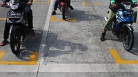 Kepolisian setempat memasang garis di jalan sebagai upaya penerapan physical distancing atau jaga jarak bagi para pemotor yang hilir mudik berkendara di kawasan tersebut.