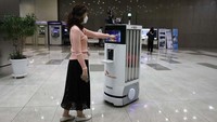 Seorang karyawan SK Telecom mendemonstrasikan robot yang akan digunakan untuk desinfeksi, memeriksa suhu tubuh di kantor pusat perusahaan pada 26 Mei 2020 di Seoul, Korea Selatan.