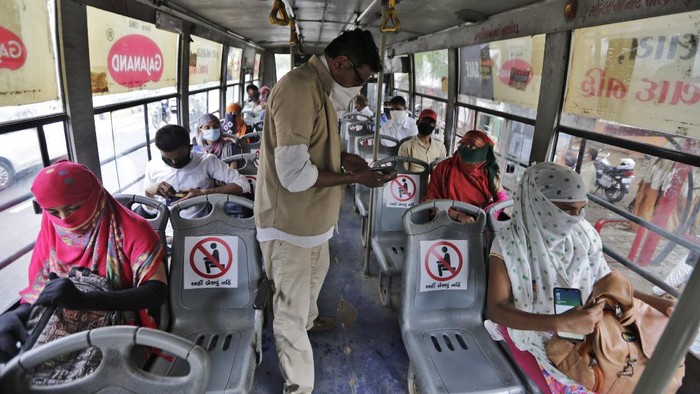 Indians board a city bus in Ahmedabad, India, Wednesday, June 10, 2020. Indias coronavirus cases are spiking amid government reopening restaurants, shopping malls and religious places in most of its states after a more than 2-month-old lockdown. (AP Photo/Ajit Solanki)