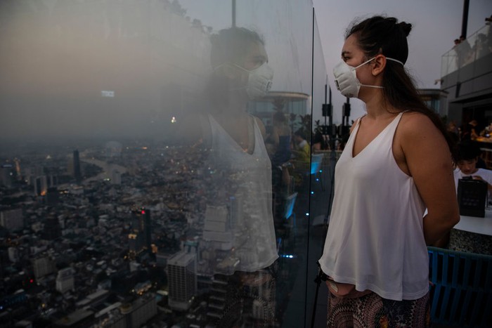 BANGKOK - JANUARY 14 : Roxana Ionicioiu from Romania wears mask at the 78-floor mirrored skyscraper viewing deck King Power Mahanakhon tower in Bangkok, Thailand on January 14, 2020. Thick, unhealthy smog continues to plague much Bangkok and the North, with the worst pollution in Lampang province near Chiang Mai. According to the Pollution Control Dept  unsafe levels of particulate matter 2.5 micrometres and less in diameter (PM2.5) at 11 of the 15 air quality measurement stations it operates in the North. (Photo by Paula Bronstein/Getty Images )