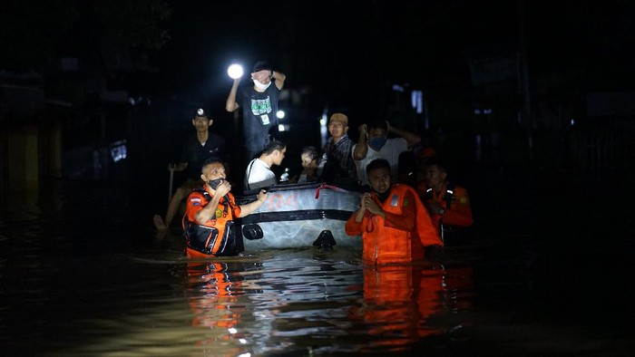 Dua warga mengungsi sambil mendorong motor ke tempat yang lebih tinggi di Kota Timur, Kota Gorontalo, Gorontalo, Kamis (11/6/2020) malam. Data sementara dari pemerintah setempat mencatat sebanyak 1.150 warga terdampak banjir dengan ketinggian air mencapai 1,5 meter. ANTARA FOTO/Adiwinata Solihin/aww.