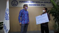 Direktur PT AXA Mandiri Financial Services (AXA Mandiri) Cecil Mundisugih, secara simbolis menyerahkan donasi kepada Ketua Umum Persekutuan Gereja-Gereja Indonesia (PGI) Pdt Gomar Gultom, di Grha Oikoumene, Jakarta.