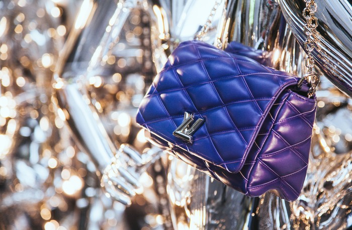 Ilustrasi tas mewah Milan, Italy - December 15, 2015: Louis Vuitton luxury leather bag in the shop window in Milans fashion district Via Monte Napoleone showcasing the latest fashion news in an original way.