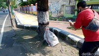 Tak sedikit warga yang mendekati karung itu untuk memotretnya.