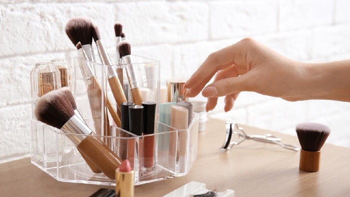 makeup Woman taking lipstick from organizer for makeup cosmetic products on dressing table