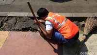 Pelanggar PSBB juga memunguti sampah yang terselip di trotoar.