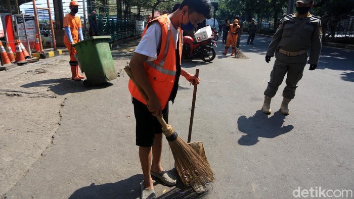Pelanggar PSBB Dihukum Sapu Jalan Pelanggar aturan pembatasan sosial berskala besar (PSBB) transisi melaksanakan sanksi kerja sosial dengan menyapu sampah di Kawasan Pasar Senen, Jakarta, Jumat (12/6/2020). Penindakan itu untuk memberikan efek jera bagi para pelanggar agar mereka patuh terhadap kebijakan PSBB sekaligus meminimalisir potensi penyebaran COVID-19.