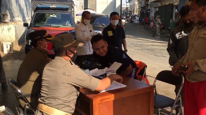 Petugas Gabungan pengawasan PSBB menggelar razia di Pasar kebayoran lama. Mereka yang tak menggunakan masker langsung dirusuh menyapu jalanan.