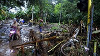 Sampah yang sebelumnya terseret arus banjir menumpuk di jalanan. 