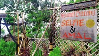 Tertera papan bertuliskan Selamat Datang, Selfie dan Amal di depan pintu masuk menuju spot berfoto tersebut.