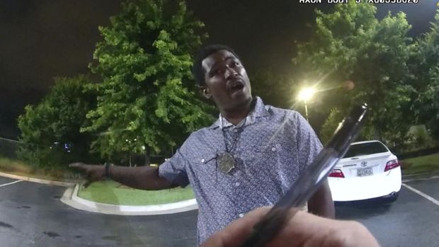 This screen grab taken from body camera video provided by the Atlanta Police Department shows Rayshard Brooks speaking with Officer Garrett Rolfe as Rolfe writes notes during a field sobriety test in the parking lot of a Wendy's restaurant, late Friday, June 12, 2020, in Atlanta. Rolfe has been fired following the fatal shooting of Brooks and a second officer has been placed on administrative duty. (Atlanta Police Department via AP)