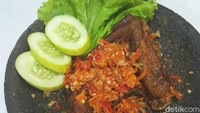 Ayam geprek tradisional ini ayam gorengnya dimemarkan di atas cobek berisi sambal yang menyengat. Enak dimakan hangat dengan lalapan. Cara membuatnya ada di resep ini. Foto: detikfood