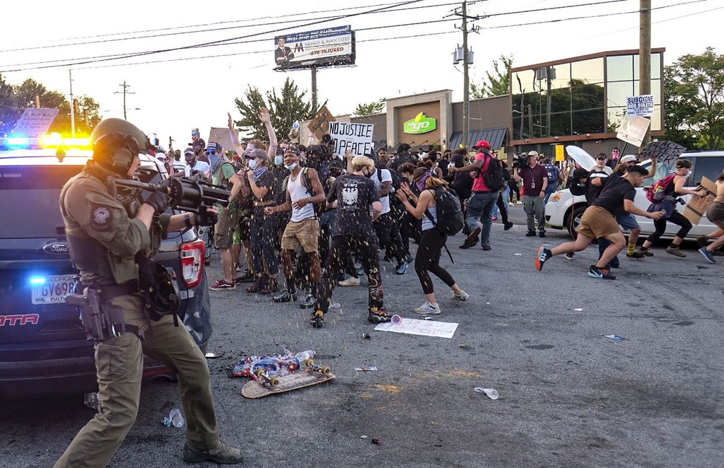 Police attempt to control protestors outside a Wendy's restaurant Saturday, June 13, 2020 in Atlanta. Georgia authorities said Saturday a man was shot and killed in a late night struggle with Atlanta police outside a fast food restaurant after he failed a field sobriety test and resisted arrest. (Ben Gray/Atlanta Journal-Constitution via AP)