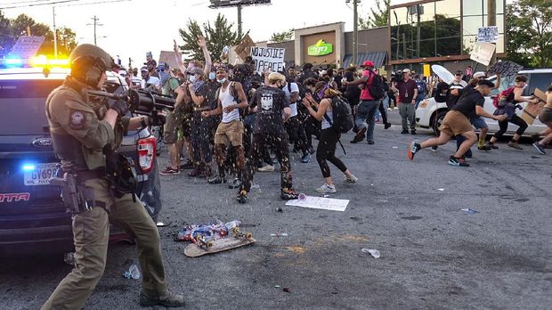 Police attempt to control protestors outside a Wendy's restaurant Saturday, June 13, 2020 in Atlanta. Georgia authorities said Saturday a man was shot and killed in a late night struggle with Atlanta police outside a fast food restaurant after he failed a field sobriety test and resisted arrest. (Ben Gray/Atlanta Journal-Constitution via AP)