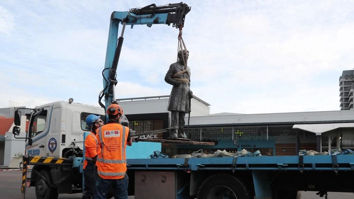 Workers remove a controversial statue of Captain John Fane Charles Hamilton from Civic Square in Hamilton on June 12, 2020, following a formal request by the Waikato-Tainui iwi (tribal confederation) and threats it would be torn down during a Black Lives Matter march due to take place the following day. - The statue of Hamilton, a British military commander who led a detachment against Maori during the Battle of Gate Pa in 1864, was removed as statues of colonial figures in Britain, Belgium and the United States were toppled by demonstrators amid worldwide protests against police brutality and racism in the wake of African American George Floyds killing by a white police officer. (Photo by MICHAEL BRADLEY / AFP)