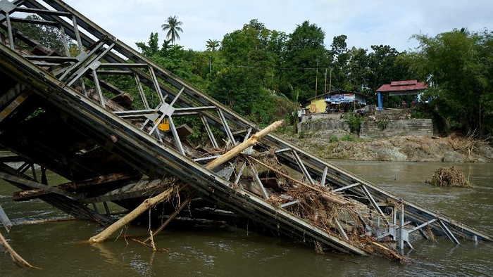 Potret Jembatan di Gorontalo yang Ambruk Diterjang Banjir Warga menyewakan jasa penyeberangan dengan menggunakan perahu untuk melintasi sungai Bone dengan tarif Rp5.000 per orang di Alale, Kabupaten Bone Bolango, Gorontalo, Minggu (14/6/2020). Jasa penyeberangan tersebut merupakan alternatif transportasi warga untuk menyeberang dari Kecamatan Suwawa Selatan dan Suwawa Tengah maupun sebaliknya akibat ambruknya jembatan penghubung yang diterjang banjir. ANTARA FOTO/Adiwinata Solihin/foc.