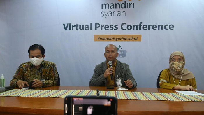 Direktur Finance, Strategy dan Treasury Mandiri Syariah Ade Cahyo Nugroho (tengah), Group Head Mandiri Syariah University Siti Nurdiana (kanan), Corporate Communication Head Mandiri Syariah Nana Suryana (kiri) tengah scan QRIS untuk penerima bantuan program Keberkahan untuk Indonesia di Kantor Pusat Mandiri Syariah Jakarta 15/6. PT Bank Syariah Mandiri (Mandiri Syariah) dan Pegawai menyalurkan 26.600 bantuan dalam bentuk paket bahan pangan kepada masyarakat terdampak Covid-19 di seluruh Indonesia.