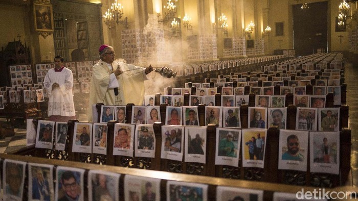Deretan Foto-foto Korban Corona Ditempel di Gereja Peru Workers stick portraits of people who died due to the COVID-19, inside the Cathedral, in Lima, Peru, Saturday, June 13, 2020. Sunday's mass in Lima's cathedral with the presence of more than 4,000 portraits of the dead from COVID-19 is the first with these characteristics in the South American country where until Saturday more than 6,400 had died and more than 225,000 were infected. (AP Photo/Rodrigo Abd)