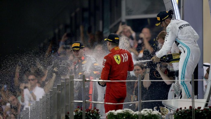 ABU DHABI, UNITED ARAB EMIRATES - DECEMBER 01: Top three finishers Lewis Hamilton of Great Britain and Mercedes GP, Max Verstappen of Netherlands and Red Bull Racing and Charles Leclerc of Monaco and Ferrari celebrate on the podium during the F1 Grand Prix of Abu Dhabi at Yas Marina Circuit on December 01, 2019 in Abu Dhabi, United Arab Emirates. (Photo by Charles Coates/Getty Images)